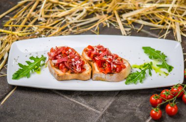 Bruschetta snack sebze ve saman ile gri arka plan üzerinde tabakta jambon ile