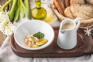 Ahşap tahta üzerinde kase ve malzemeler içinde sebze krem çorbası