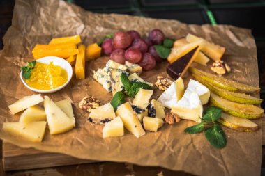 Parşömen üzerine peynir ve meyve meze eşliğinde