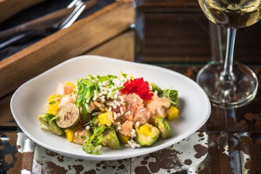 İncelik sebze salatası kadeh beyaz şarap ile koyu arka plan üzerinde tabakta servis