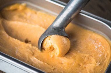 şeftalili dondurma kaşık ile kapsayıcısında closeup