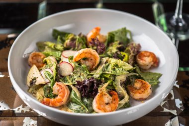 Tabak koyu arka plan üzerinde ızgara karides ile sebze salatası