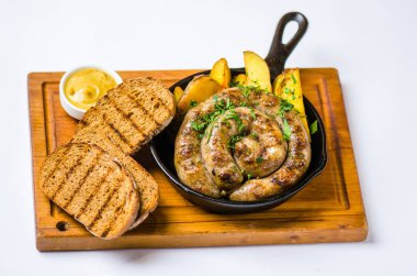 Kızarmış ekmek ve ahşap tahta üzerinde kavrulmuş patates kızartma tavada kızarmış sosis