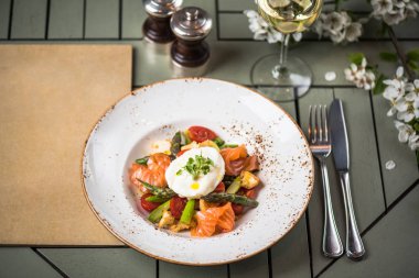 Buğulanmış sebze somon dilimleri ve yumurta pashot üst plaka ayarı tablo üzerinde devam eder