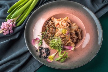 İtalyan makarna ile karanlık masa örtüsü tabakta servis et