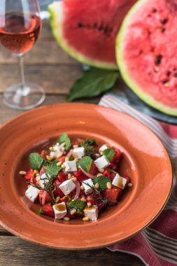 Ahşap masa tabakta servis peynirli taze sebze salatası