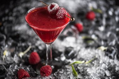 Martini cam buz ile koyu arka plan üzerinde dondurulmuş ahududu ile kokteyl