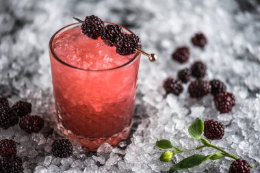 Kokteyl cam buz ile koyu arka plan üzerinde böğürtlen ile dekore edilmiş