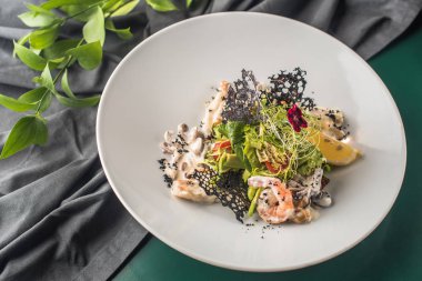 Deniz ürünleri meze koyu arka plan üzerinde beyaz plaka üzerinde