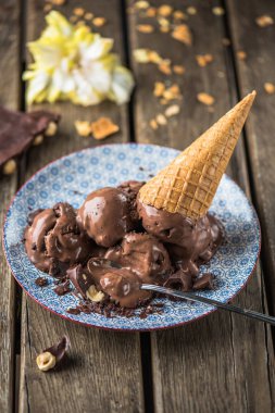 Çikolatalı dondurma topları desen ahşap masa üzerinde gözleme koni ile tabakta