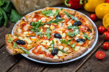Roka ve ahşap masa tabakta servis zeytin İtalyan pizza