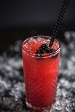 Kokteyl cam buz koyu arka plan üzerinde taze böğürtlen ile