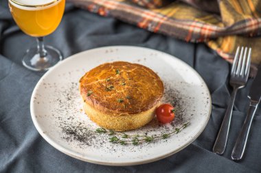 Ev yapımı tuzlu pasta plaka üzerinde gri masa örtüsü domatese ile pişmiş