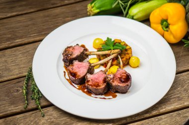 Kemikler sebze ve sos ahşap masa üzerinde beyaz tabakta et