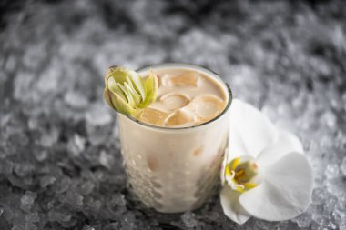 Kokteyl cam buz ve orkide çiçek ile koyu arka plan üzerine servis