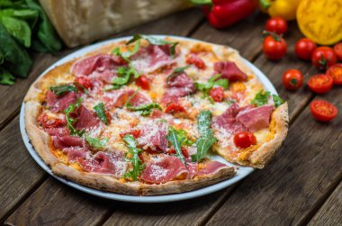 et, roka, parmesan ve kiraz domates ile güzel pişmiş pizza ahşap masa üzerinde görmek