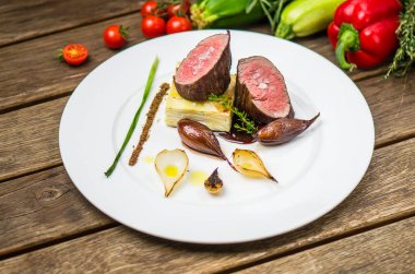 Ahşap masa üzerinde beyaz plaka üzerinde ızgara soğan ile balık