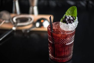 Yaprak ve koyu arka plan üzerinde yaban mersini taze kokteyl cam süslenmiş