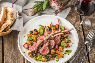 Eti fileto malzemelerle ahşap masa üzerinde plaka üzerinde soslu sebzeli kemikleri üzerinde