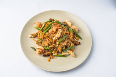 Beyaz arka planda tabak kızarmış sebze ve tavuk ile Asya noodle