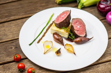 Ahşap masa üzerinde beyaz plaka üzerinde ızgara soğan ile balık