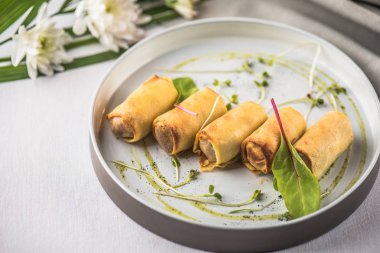 Doldurulmuş Krep çiçeklerle beyaz masa örtüsü tepside servis haddelenmiş