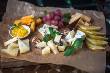 Parşömen üzerine peynir ve meyve meze eşliğinde