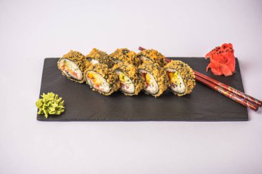 Japon suşi roll beyaz arka plan üzerinde yemek çubukları ile kayrak üzerinde servis tava