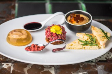 Biftek tartar, Etli jöle ve tost koyu arka plan üzerinde meze tabağı