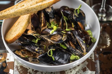 Koyu arka plan üzerinde ekmek ile yağda pişirilmiş midye kase