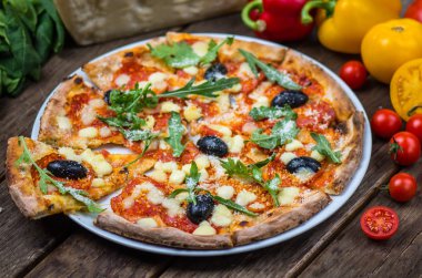Roka ve ahşap masa tabakta servis zeytin İtalyan pizza