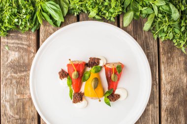 Ahşap masa üzerinde beyaz tabakta servis biber dolması