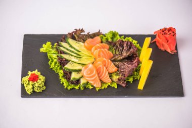 Beyaz arka planda arduvaz üzerinde taze Japon deniz ürünleri sashimi