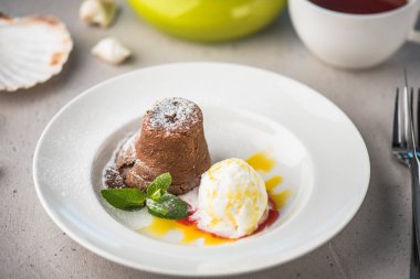 Vanilyalı dondurma ile beyaz plaka üzerinde kahve masada ile çikolatalı kek
