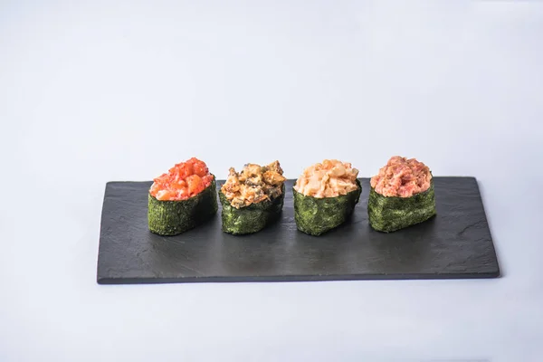 灰色の背景のスレート板でマグロと海苔ポン酢美味しい伝統的な様々 な寿司 — ストック写真