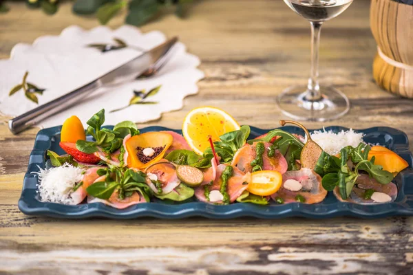 Fish platter garnished with herbs and citrus fruit on wooden table