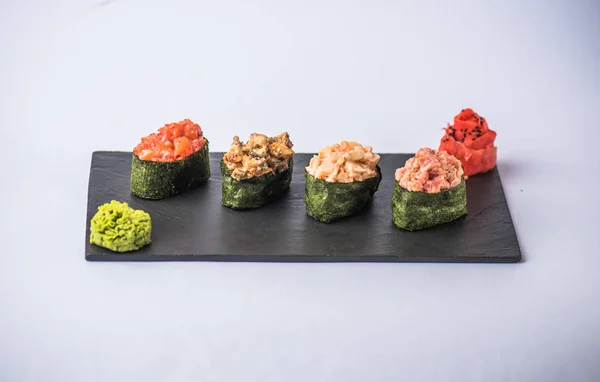 灰色の背景のスレート板で魚介類 わさび 生姜と様々 な美味しい寿司のクローズ アップ ビュー — ストック写真