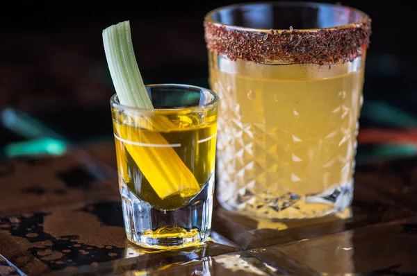 alcohol drinks in glass and shot-glass on brown tiled surface