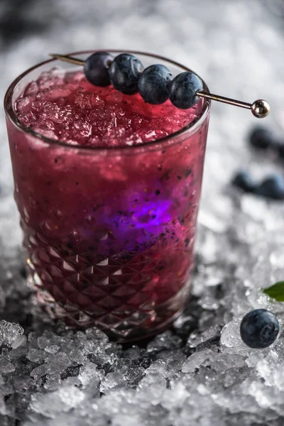 新鲜的鸡尾酒在玻璃装饰与蓝莓在黑色的背景与冰棒 — 图库照片