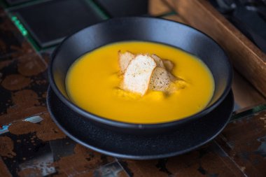 Siyah kase croutons süslenmiş krem balkabağı çorbası