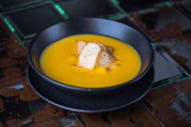 Siyah kase croutons süslenmiş krem balkabağı çorbası