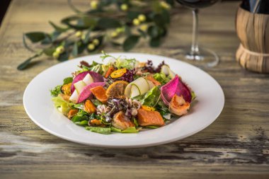 Ahşap masa üzerinde beyaz plaka üzerinde kızarmış tavuk ile sebze salatası