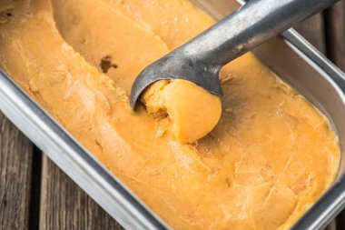 şeftalili dondurma kaşık ile kapsayıcısında closeup