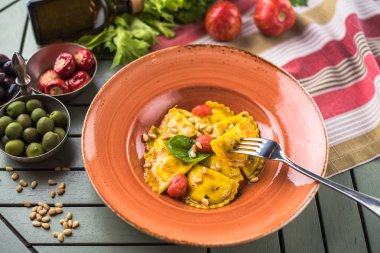 Makarna Mantı domates ve çam fıstığı ile tablo malzemelerle tabakta servis