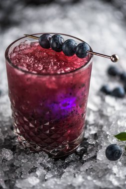 Stick buz ile koyu arka plan üzerinde yaban mersini taze kokteyl cam süslenmiş