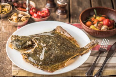 kase sebze ile ahşap masa üzerinde plaka üzerinde tek balık ızgara