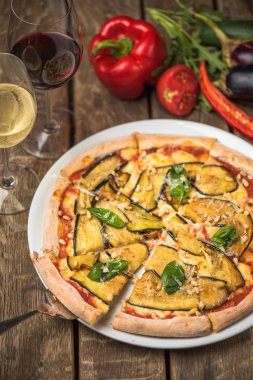 Fırında patlıcan ve çam fıstığı ahşap masa üzerinde tabakta sebze pizza