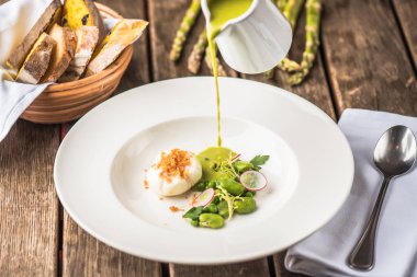 ahşap masa üzerinde plaka ile hamur tatlısı kremalı sebze çorbası dökme