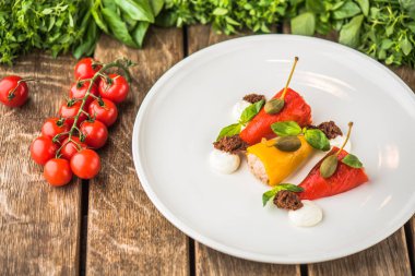 Ahşap masa üzerinde beyaz tabakta servis biber dolması