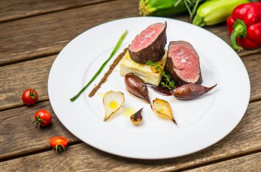 Ahşap masa üzerinde beyaz plaka üzerinde ızgara soğan ile balık